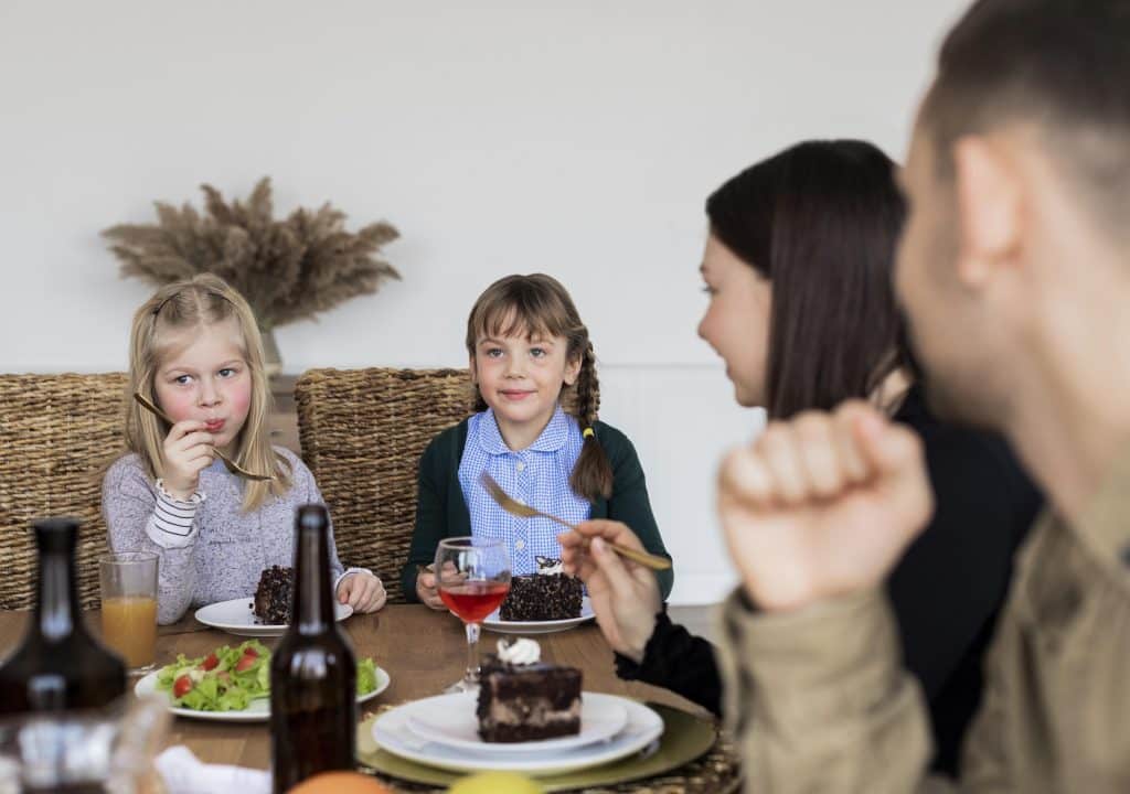 Famille à table avec les enfants qui sont au centre de l'attention.