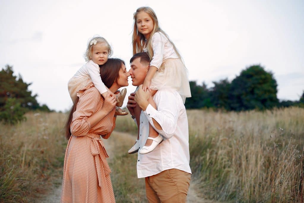 Famille faisant une promenade en campagne, les parents s'embrassent.