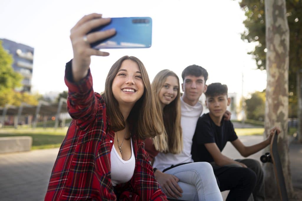 Ados prenant des selfies au skate park.